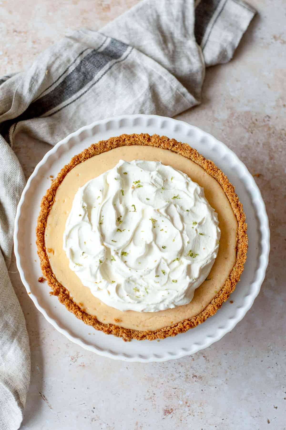 Key Lime Pie with cream on a white ceramic dish.