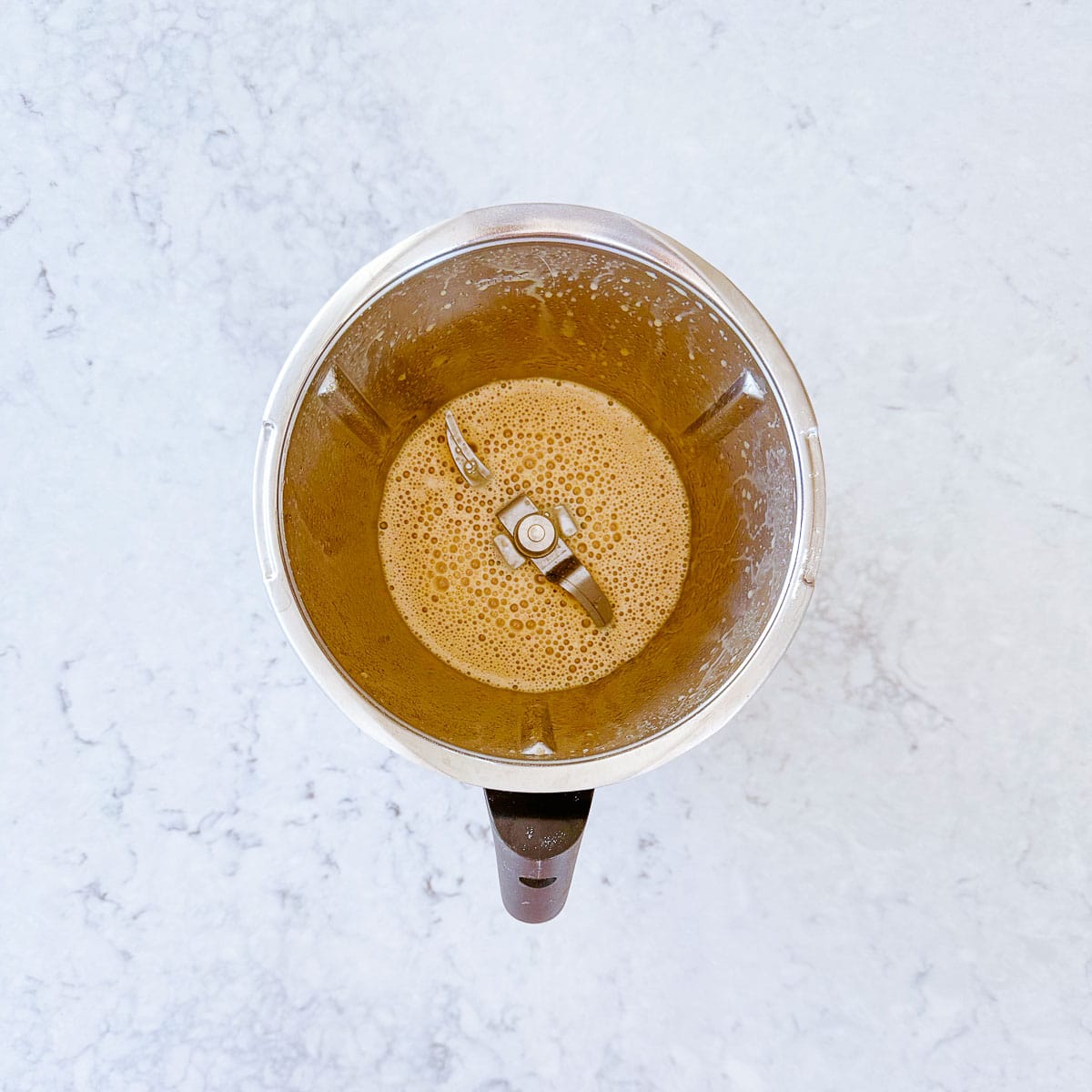 A mixture of eggs, sugar and oil in a Thermomix bowl.