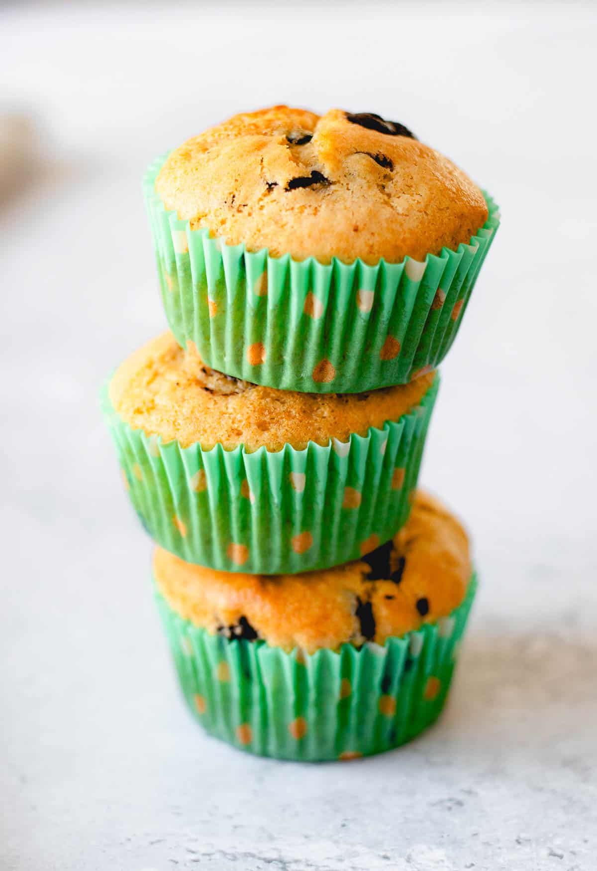 3 chocolate chip muffins stacked on top of each other.