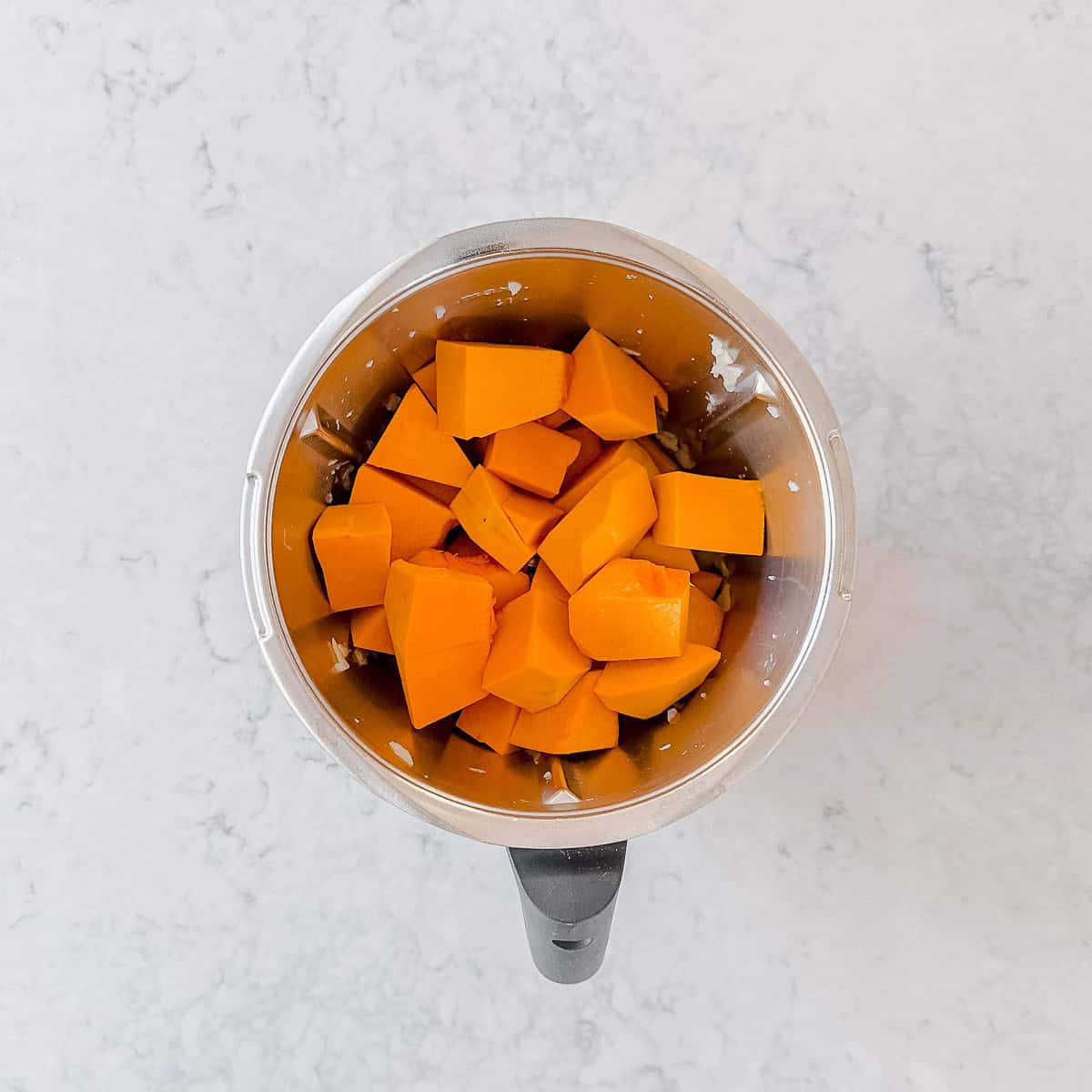 Chopped pumpkin in a Thermomix bowl.