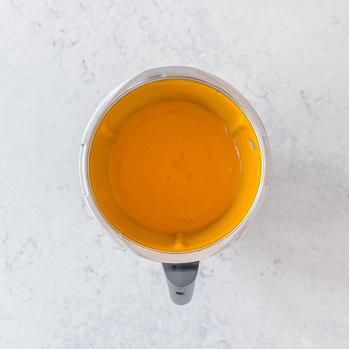 Blended pumpkin soup in a Thermomix bowl.