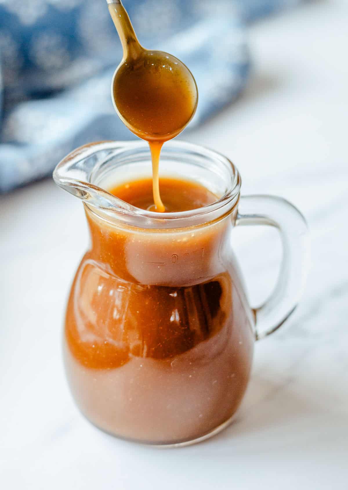 Butterscotch sauce in a glass just with teaspoon.