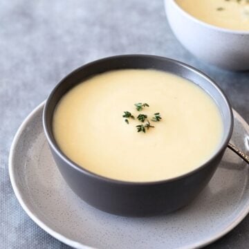 2 Bowls of Celeriac Soup on a grey table.