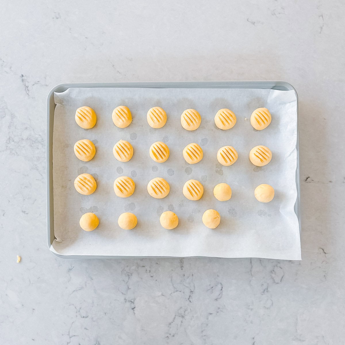 Raw melting moments on a baking tray, ready to be baked.
