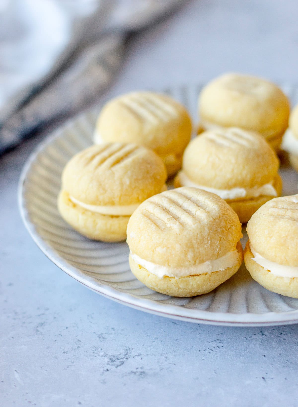 Melting moments on a grey plate, sitting on a grey marble benchtop.