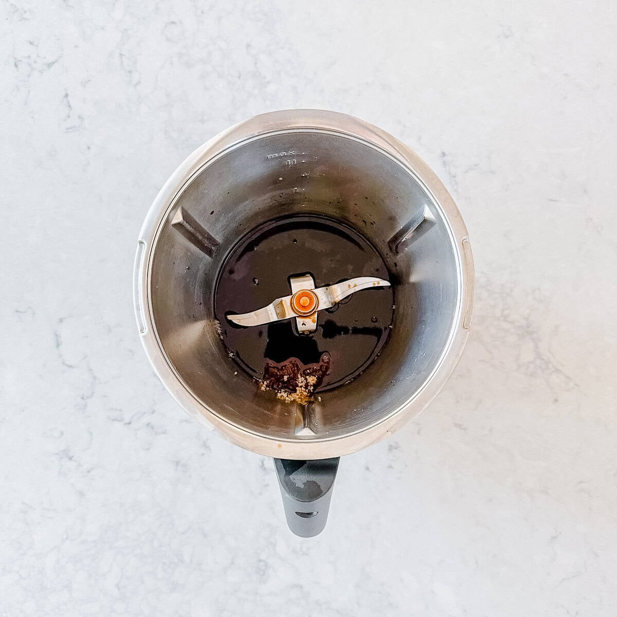 A top down view of a Thermomix bowl containing balsamic vinegar and brown sugar.