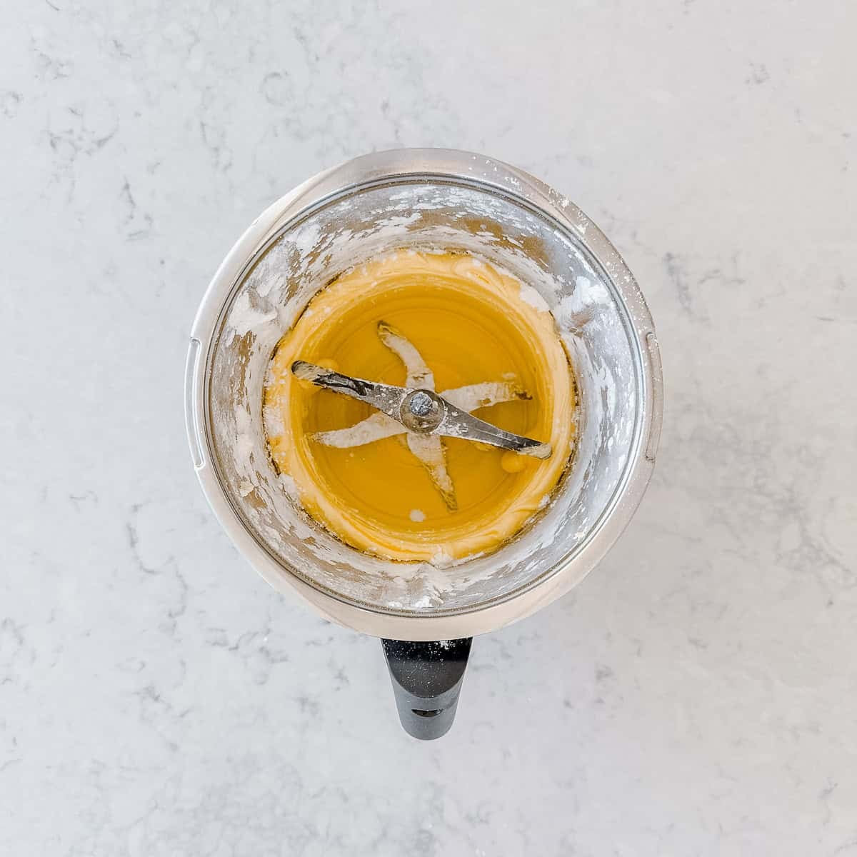 Butter and icing sugar whisked into a pale, creamy mixture around the butterfly whisk.